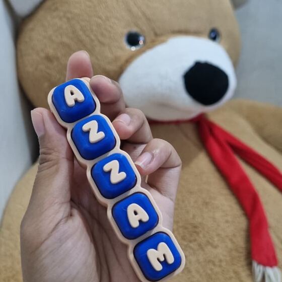Fidget clicker nama Azzam digenggam tangan