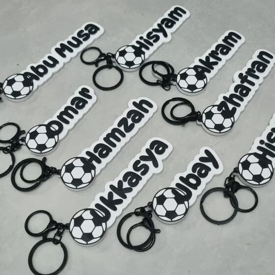 Sembilan gantungan nama hitam putih dengan charm bola sepak